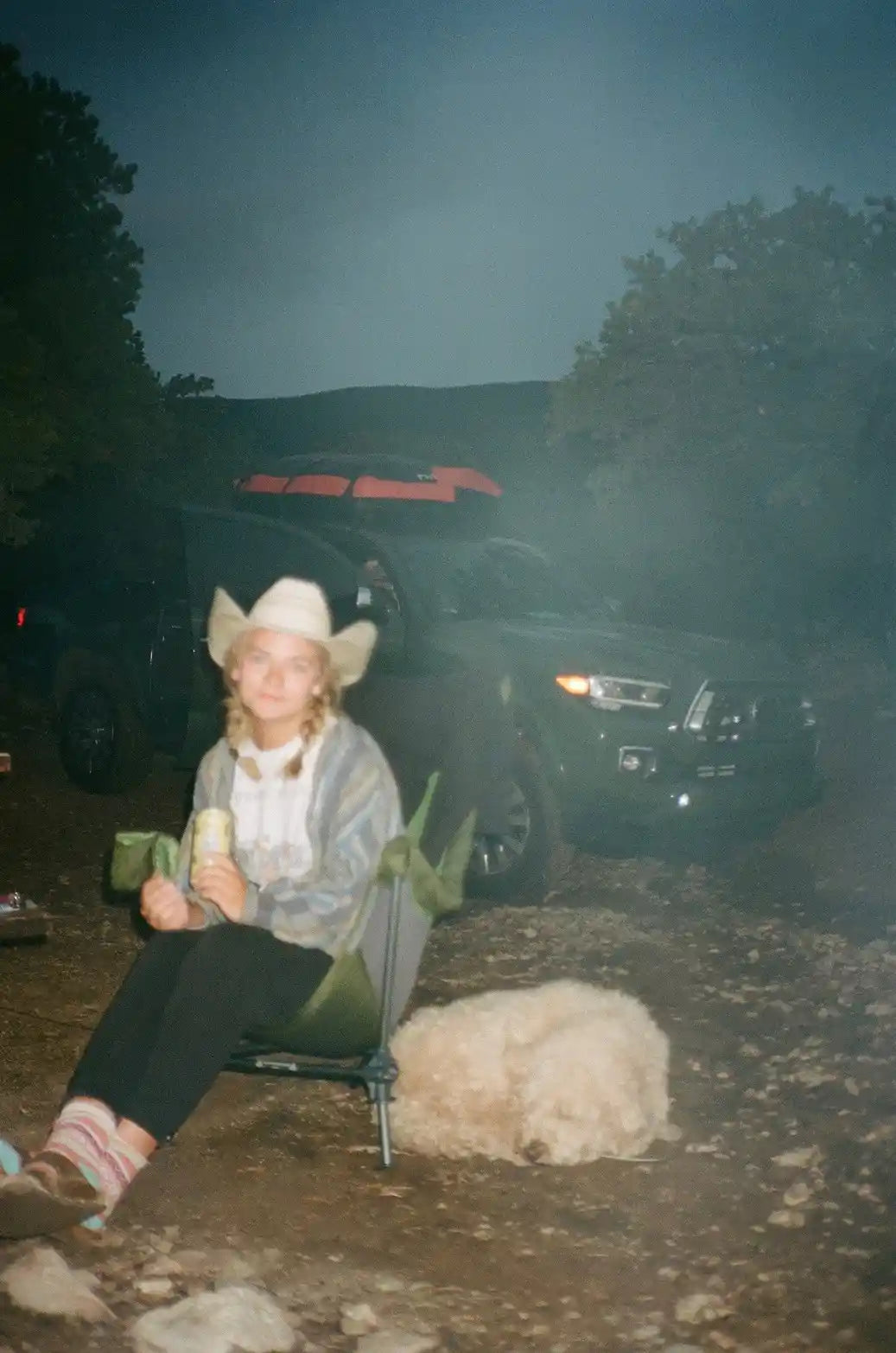 Person sitting in front of Toyota Tacoma with overland camping setup