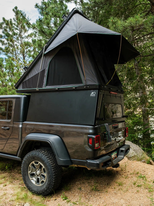 Jeep Gladiator truck bed camper with roof top tent in forest