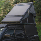 Toyota Tacoma with Truck Bed Camper and Rooftop Tent in the Forest