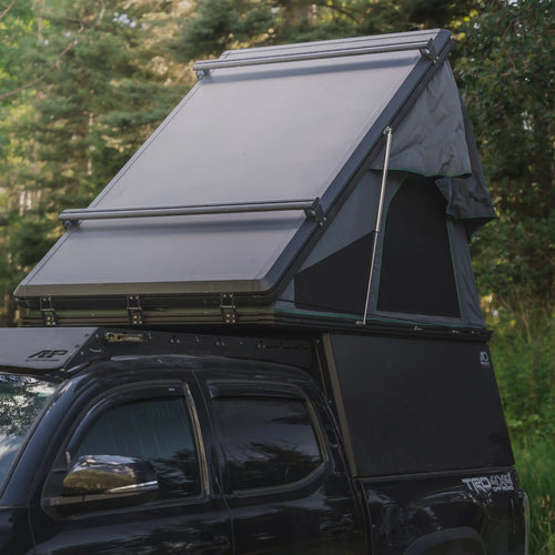 Toyota Tacoma with Truck Bed Camper and Rooftop Tent in the Forest