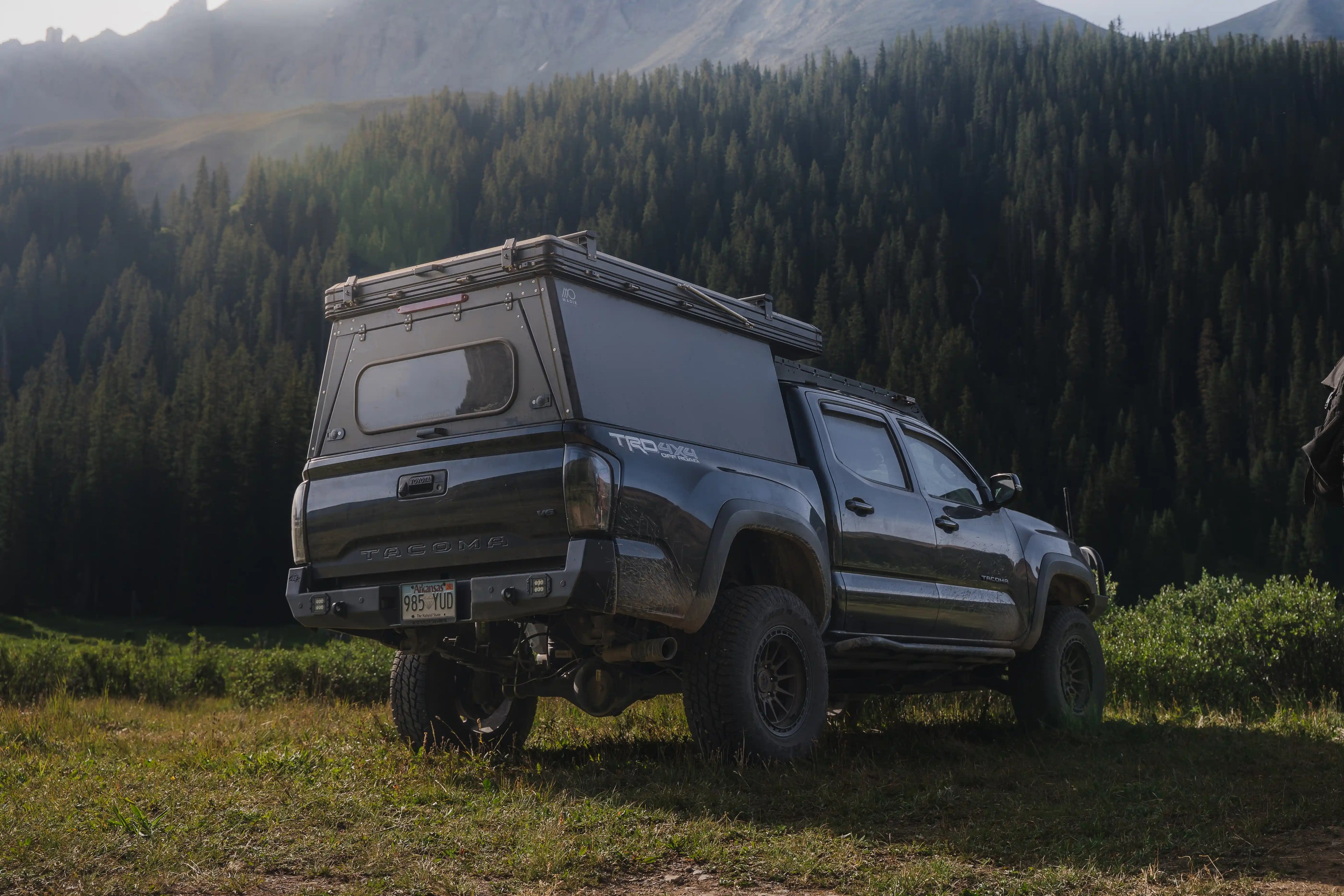 Toyota Tacoma with Madix Drift truck camper in the forest.